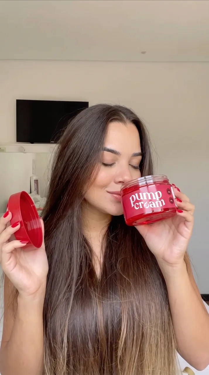 Mulher de olhos fechados sentindo o cheiro do pote aberto de Pump Cream
